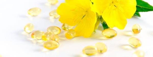 cápsulas de aceite de onagra con una flor al lado