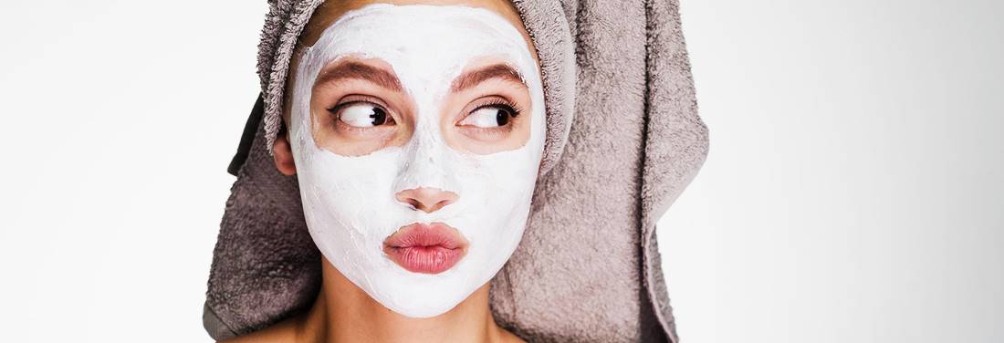 mujer con una toalla en la cabeza y una máscara de belleza